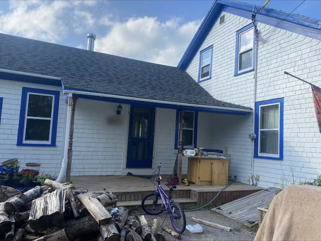 Shingled house with window, door and fascia trim painted bright blue