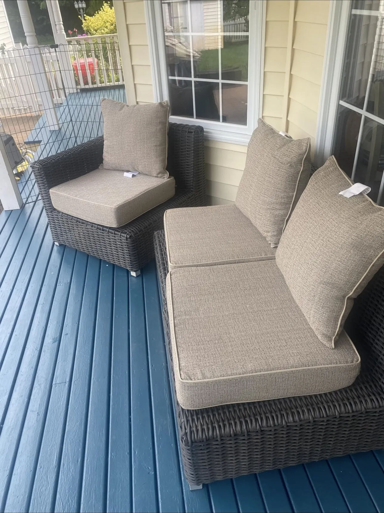 Covered porch deck freshly painted deep blue with patio furniture