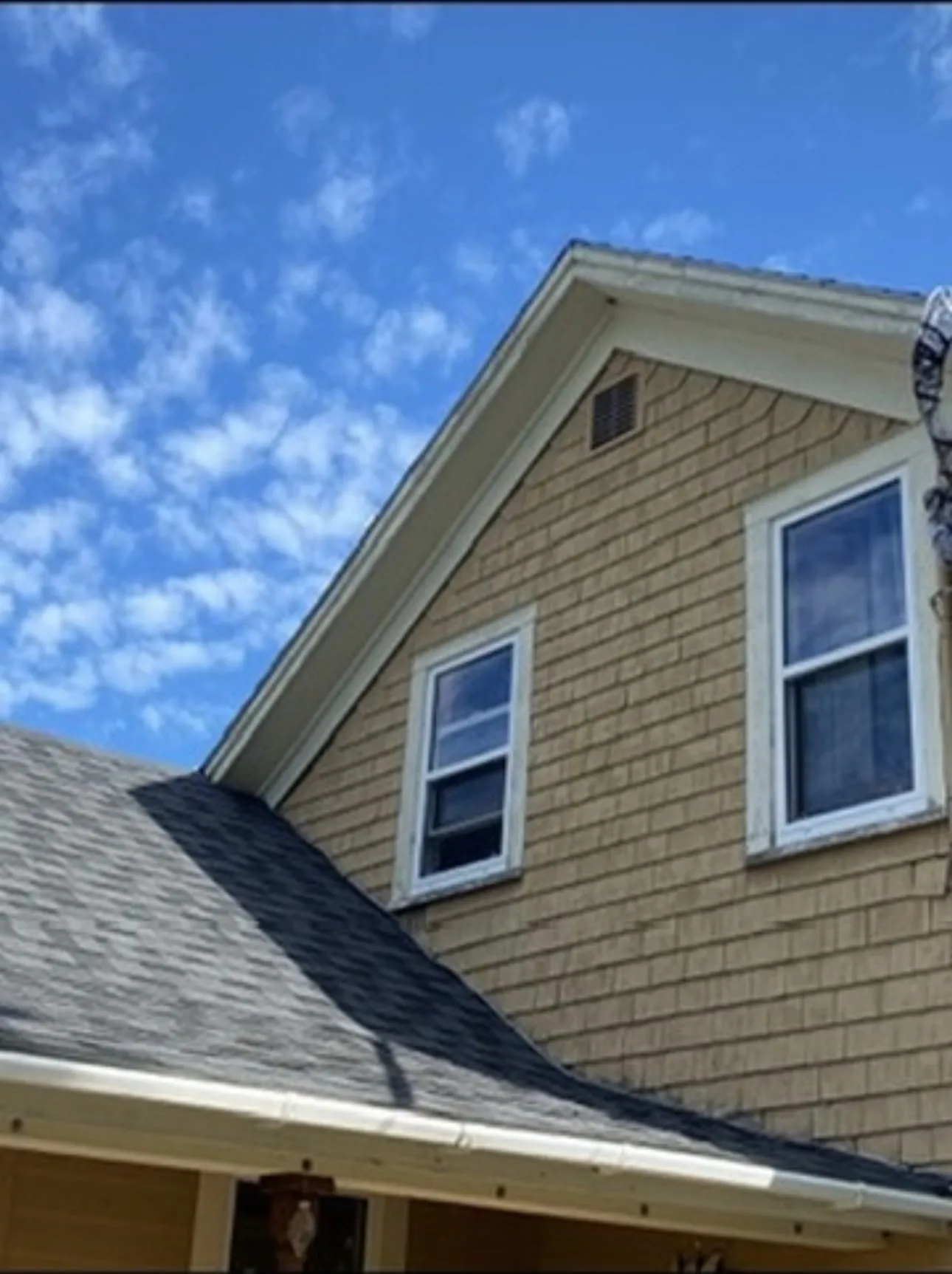 Shingled gable with white window trim and fascia